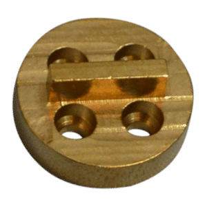 Circular brass mounting plate with a rectangular clamp across the center and four through-holes, likely a machinist jig component