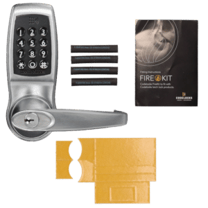 Keypad deadbolt with handle, four magnetic cards, FireKit instruction manual, and yellow packing inserts laid out on a black background