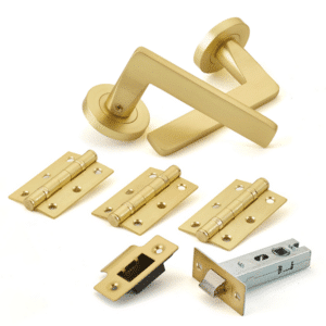 Brass door handle set with latch, hinges, and strike plates laid out on a white background.